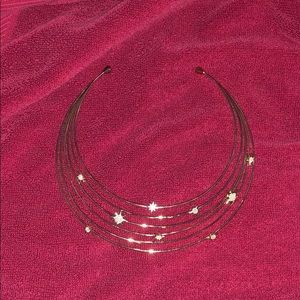 A gold necklace with stars on the bands